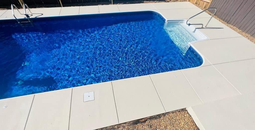 In-ground pool with concrete deck surround